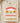 Natural tan Labor Day philosophy quote graphic tee folded on wooden board showing "Essential to Human Happiness" design with industrial labor graphics
