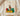 Cream Comfort Colors Black Owned shirt with crowned fist graphic breaking chains in Pan-African colors folded on wooden board with soft blankets