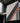 Scrim vinyl banner hung by cables from a concrete and glass building facade