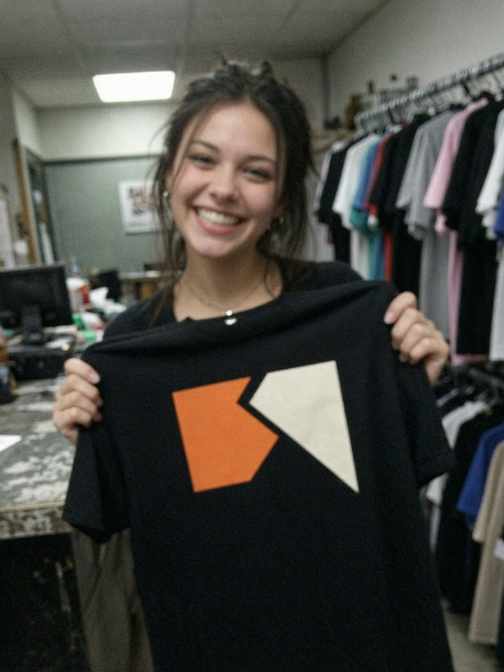 Customer holding a printed tee in the shop